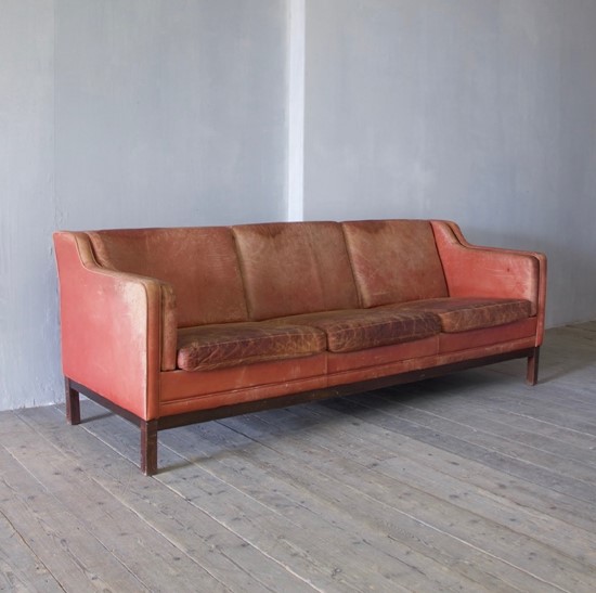 A large mid-century red leather sofa