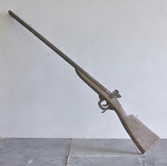 An oversized wooden model of a gun