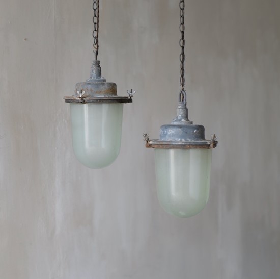 A pair of large industrial pendant lights